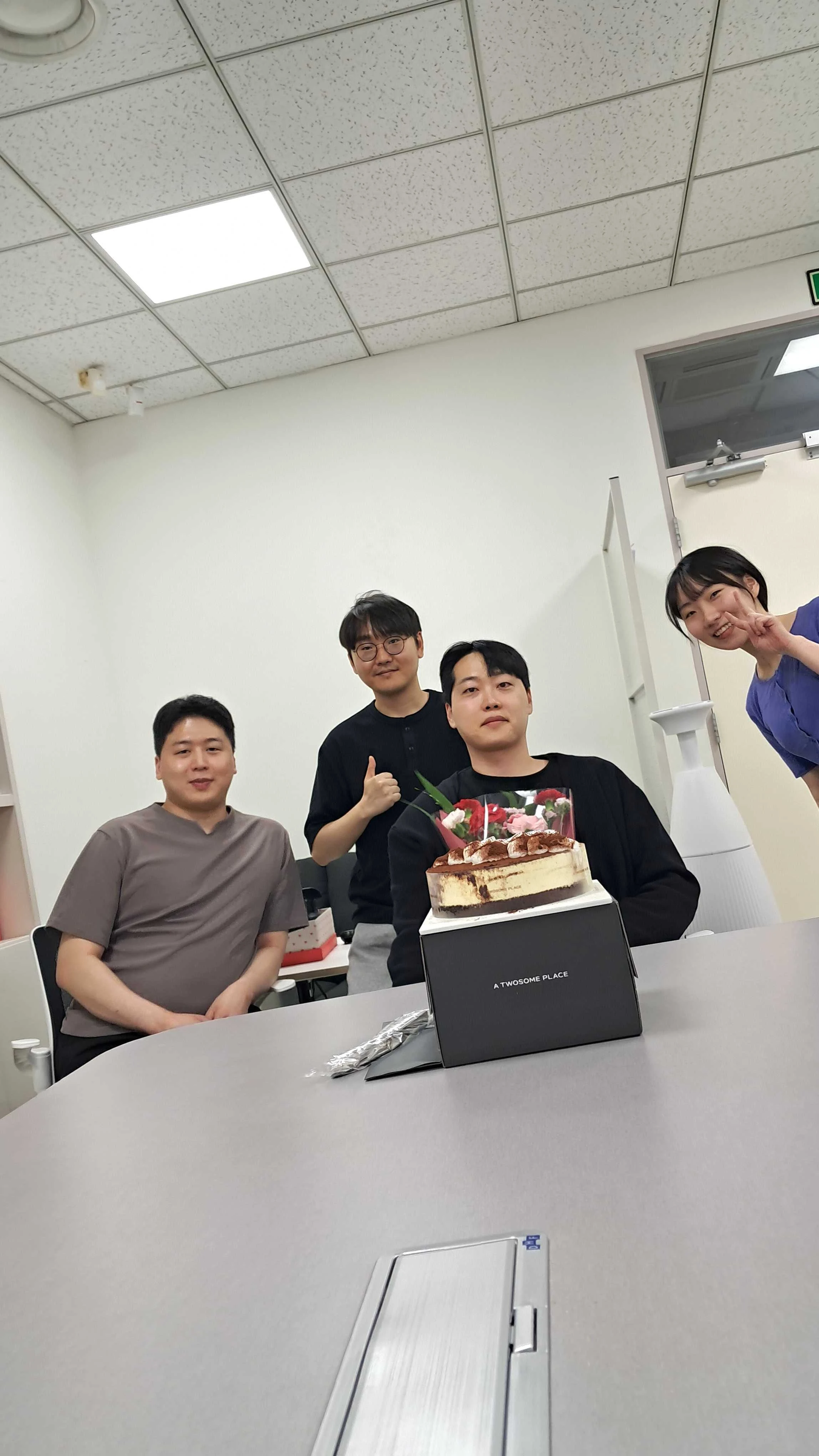 SERA Lab members celebrating together with flowers and a cake