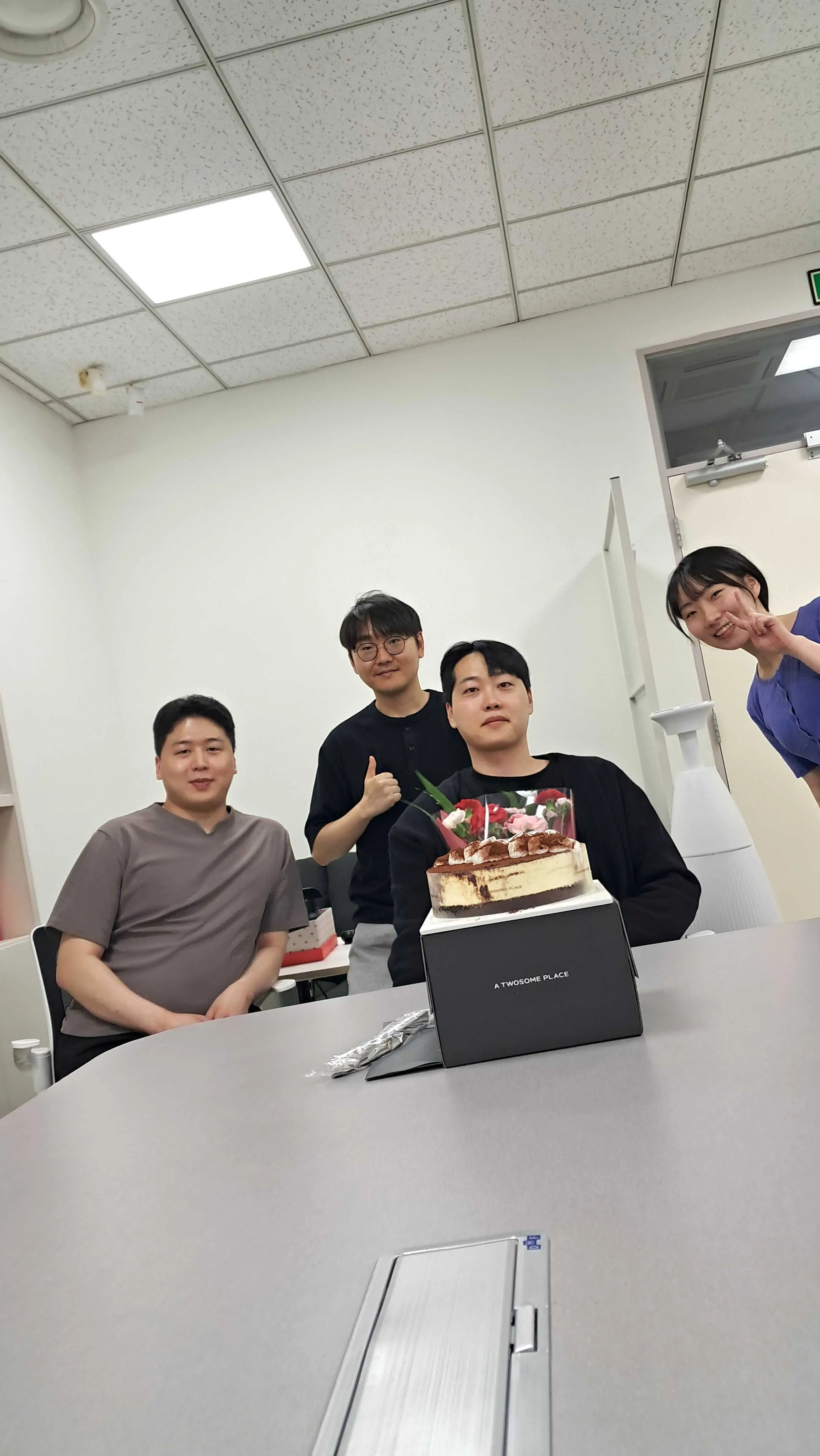 SERA Lab members celebrating together with flowers and a cake